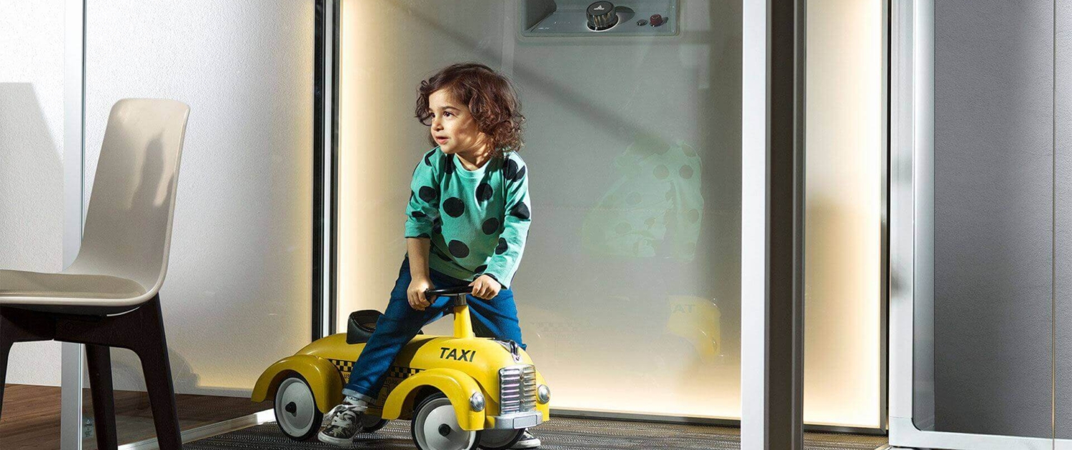 child is riding a toy car in a room
